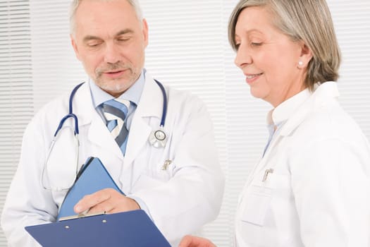 Medical doctor team senior woman and mature man holding folders