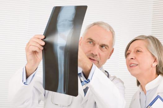 Medical doctor team senior man with female colleague look x-ray