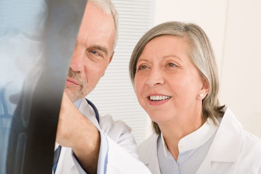 Medical doctor team senior man with female colleague look x-ray