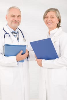 Medical doctor team senior woman and mature man holding folders