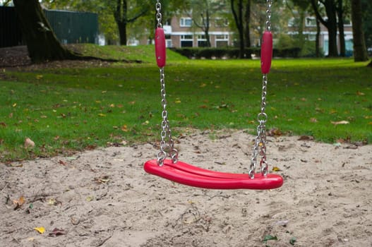 red swing in a public playground