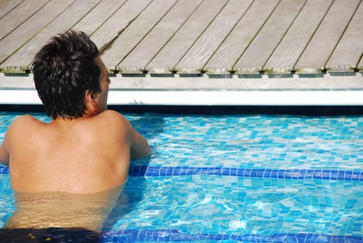 handsome man relaxing at the swimming pool