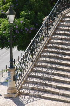beautiful close up of a typical stairway made of calcada pavement with a gorgeous retro lamp post