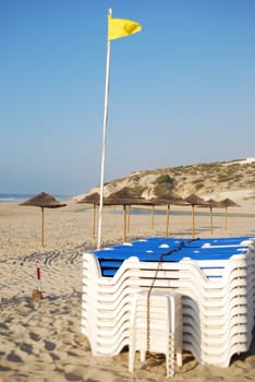 locked beach chairs with yellow flag and coconut zone
