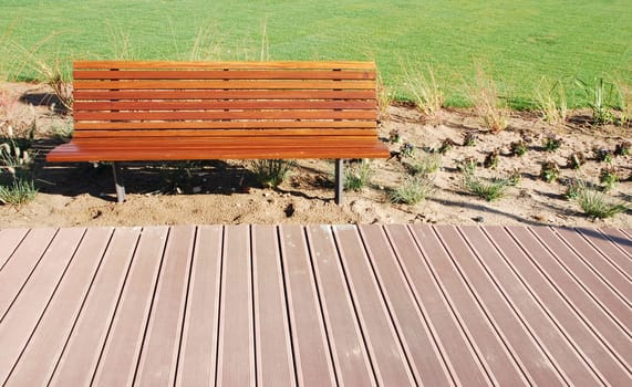 photo of a an empty park bench in a green park