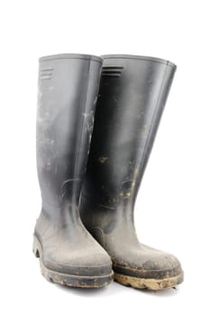 pair of muddy farmer boots isolated on a white background