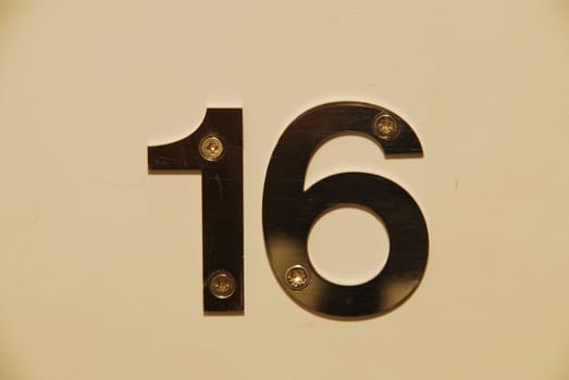 white flat metallic number hanging on the door