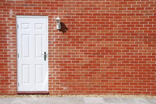 outdoor architecture with white door on a vibrant red brick wall