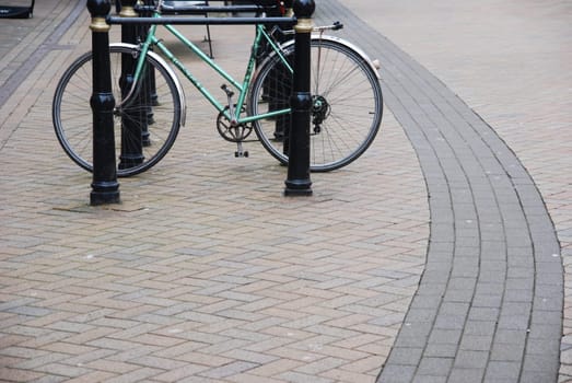 green bicycle on a parking rack at a urban street