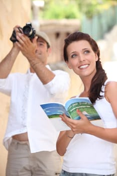 Tourists with camera and travel guide