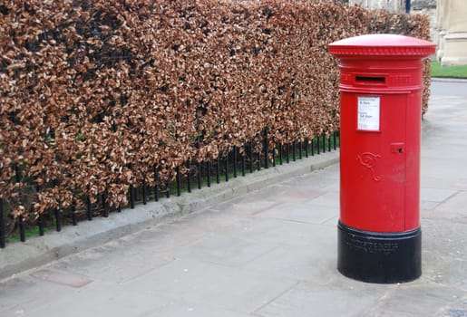 red and vintage british postbox on the sidewalk
