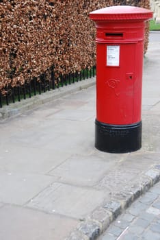 red and vintage british postbox on the sidewalk