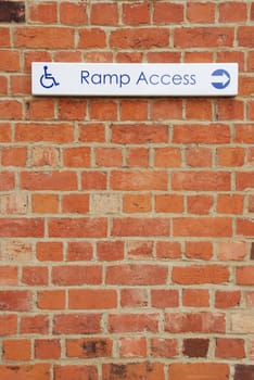 ramp access sign on a brick wall background