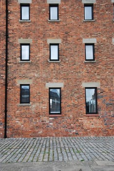 antique brick wall building with windows (british architecure in Gloucester, England, UK)