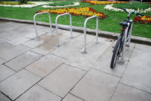 bicycle on a parking rack at a urban street (beautiful garden background)