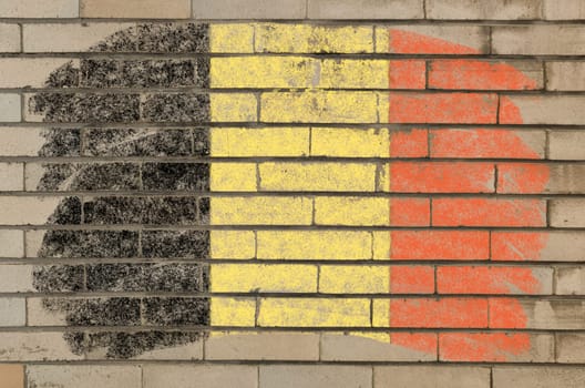 Chalky belgian flag painted with color chalk on grunge old brick wall