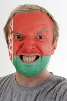 High key portrait of an angry man whose face is painted in colors of belarus flag