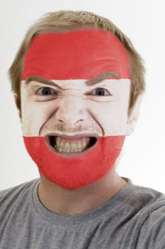 High key portrait of an angry man whose face is painted in colors of austria flag
