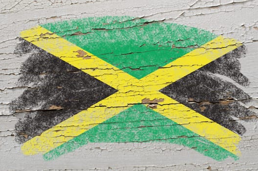 Chalky jamaican flag painted with color chalk on grunge wooden texture