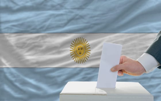 man putting ballot in a box during elections in argentina