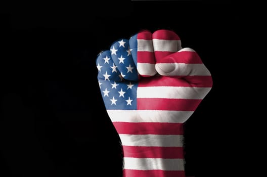 Low key picture of a fist painted in colors of american flag