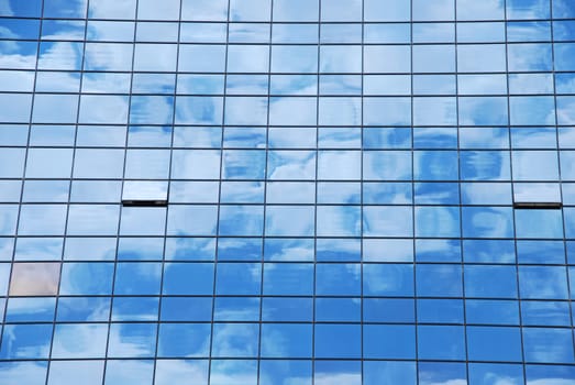 modern office building with glass pattern with clouds reflected