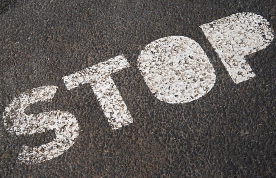 stop sign painted on a asphalt road surface