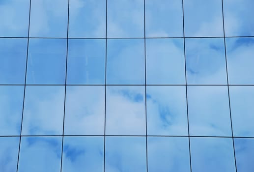 modern office building with glass pattern with clouds reflected