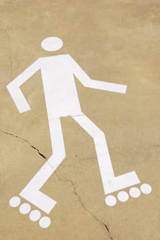 white rollerblading sign on a urban park (yellow cement surface)