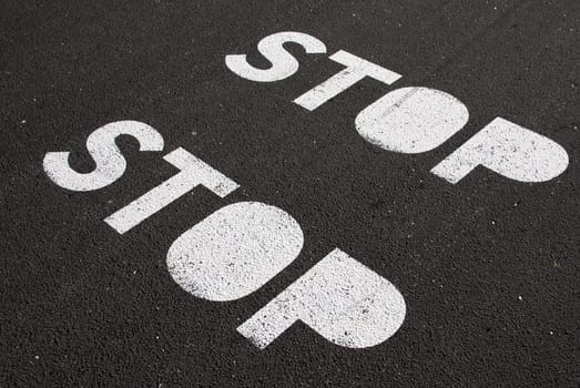stop signs painted on a asphalt road surface