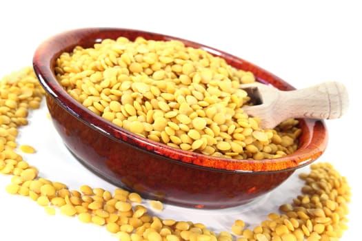 a red bowl with yellow lentils and scoop