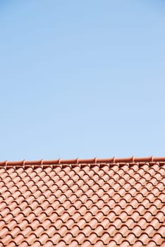 orange tiles on the roof of a house against blue sky background