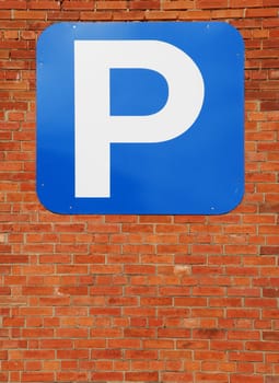 blue parking sign at a red brick wall background