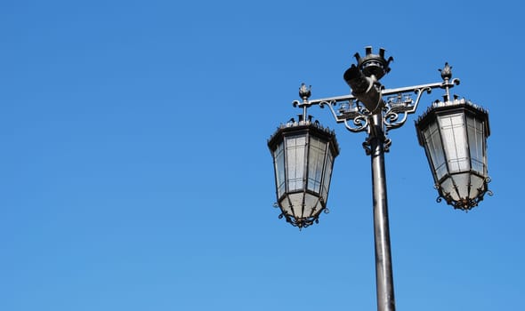 vintage lamp posts against blue sky background
