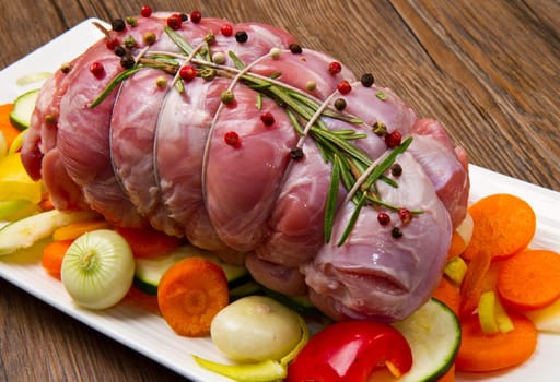 roast of beef with fresh vegetables ready to cook