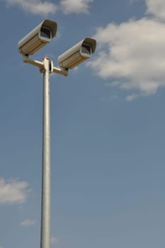 video surveillance cameras against blue sky background