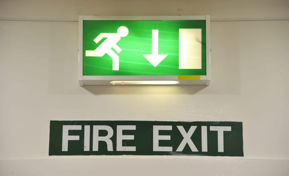 green and white warning sign glowing regarding fire exit emergency