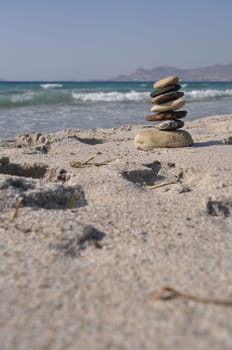 beautiful pebble stack on a sandy beach (sea on the background)