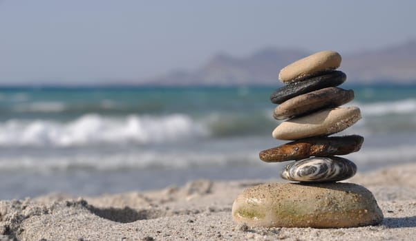 beautiful pebble stack on a sandy beach (sea on the background)