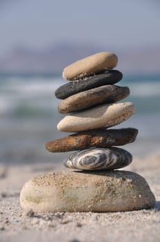 beautiful pebble stack on a sandy beach (sea on the background)
