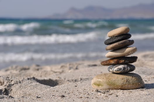 beautiful pebble stack on a sandy beach (sea on the background)
