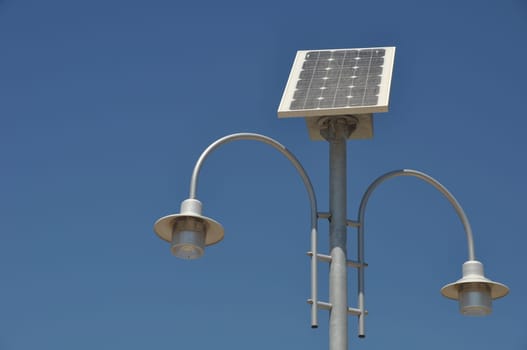 street lamp post with solar panel energy (against blue sky background)