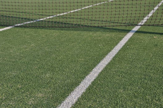 white lines on an outdoor tennis court (artificial grass)
