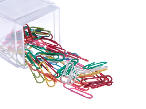 colored paper clips outside a plastic box isolated on white background