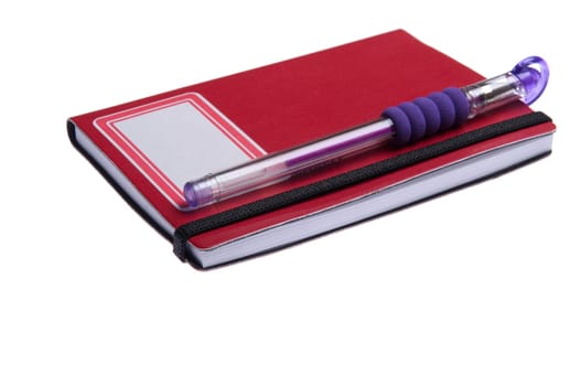 red notebook diary or agenda and purple pen lying on the top (isolated on white background)