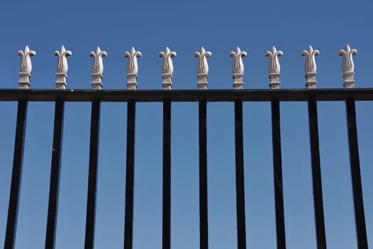 detail of a iron gate against blue sky background