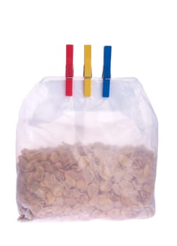 plastic cornflakes bag with clothes pegs isolated on white background
