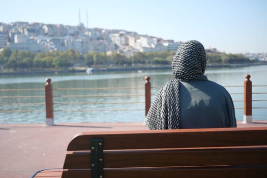 Unhappy girl sitting on a park bench .