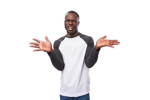 young positive african man dressed in a spring jacket on a white background with copy space.