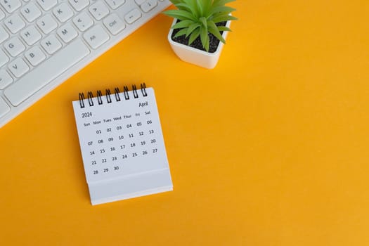 April 2024 desk calendar on yellow background. Directly above. Flat lay. Copy space.